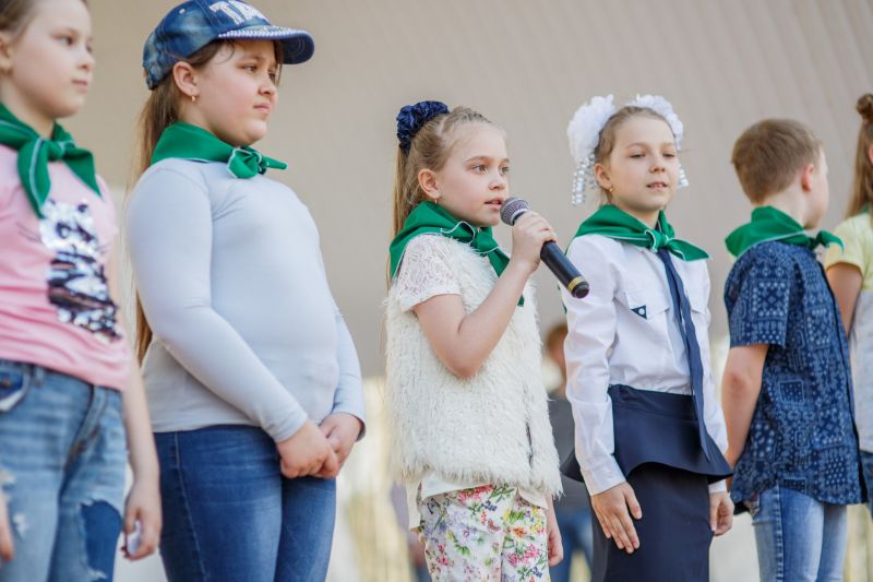 Каникулы у школьников в мордовии. Школьный экодвор конкурс. Общее фото с косынками в одинаковой одежде учеников.